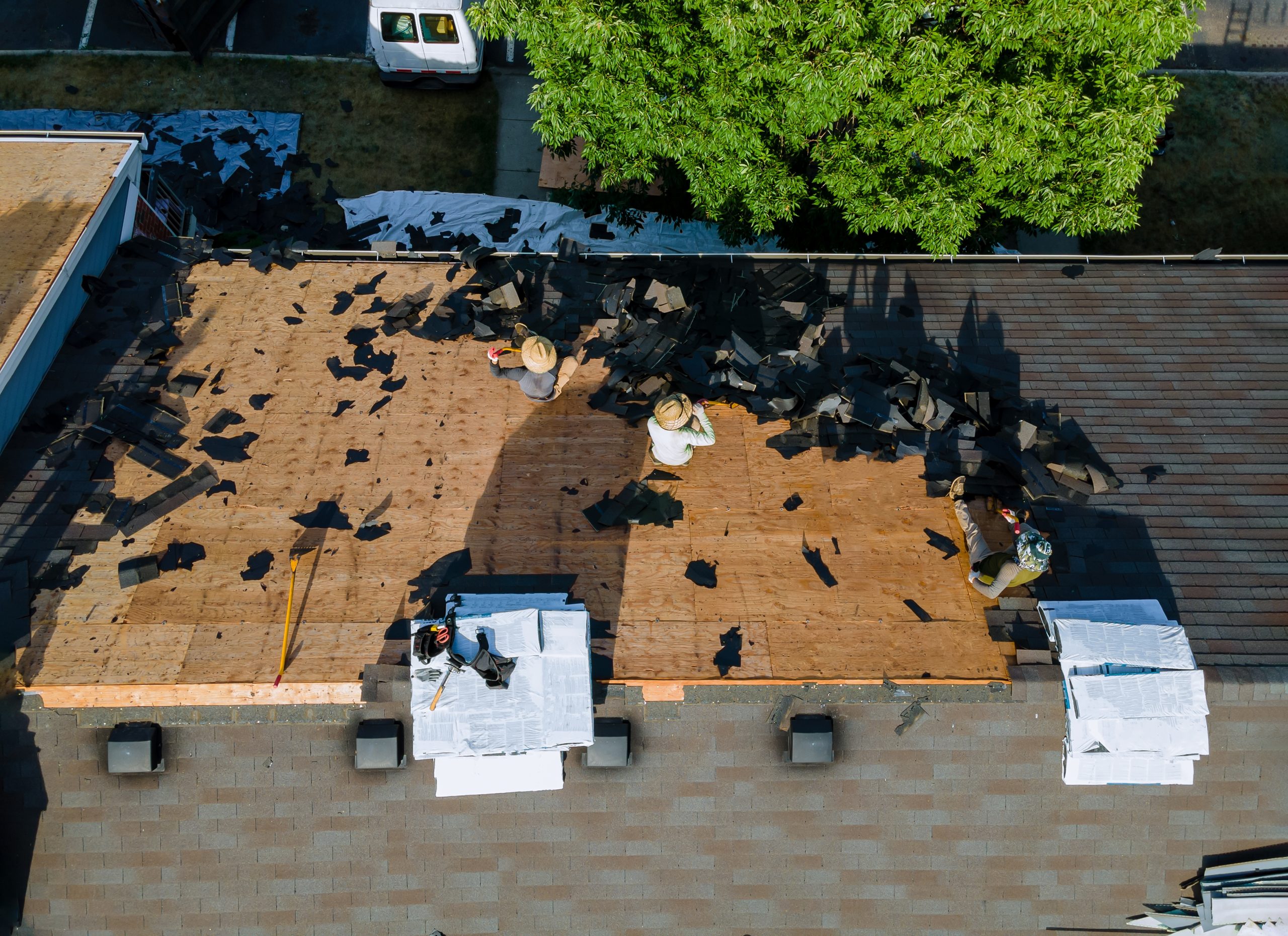 Roofers replacing the roof of a residential building